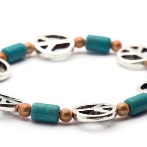 May include: A turquoise and gold peace sign bracelet with silver peace sign charms.