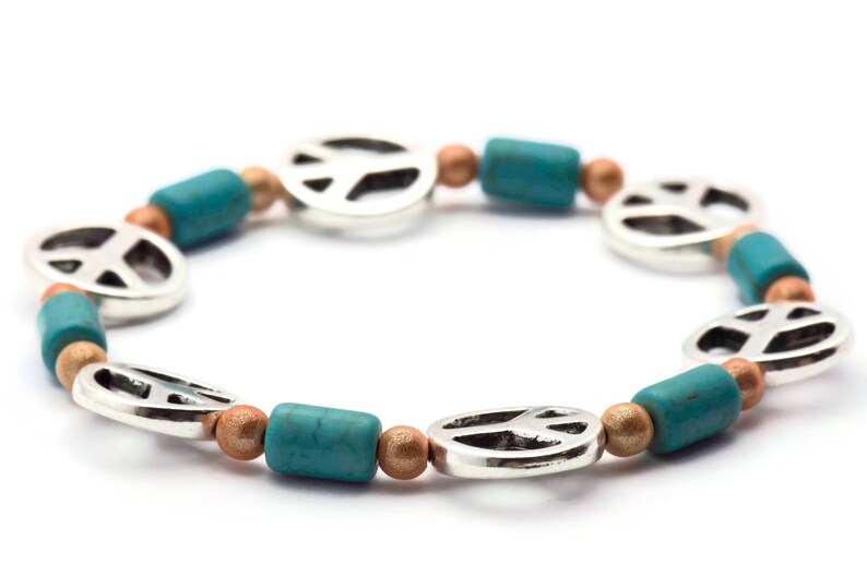 May include: A turquoise and gold peace sign bracelet with silver peace sign charms.