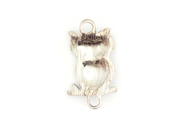 May include: Silver owl charm with a detailed design. The charm has two loops for attaching to a bracelet or necklace.