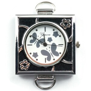May include: A silver square watch with a black face and a white dial. The dial has a butterfly design and the text "Geneva" printed on it.