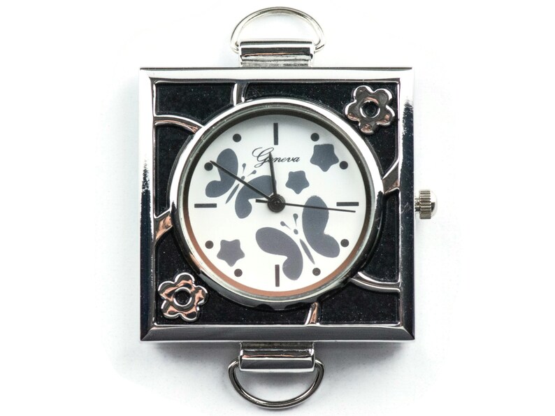 May include: A silver square watch with a black face and a white dial. The dial has a butterfly design and the text "Geneva" printed on it.