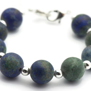May include: A blue and green gemstone bracelet with silver beads and a silver clasp.