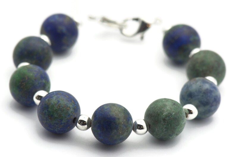 May include: A blue and green gemstone bracelet with silver beads and a silver clasp.