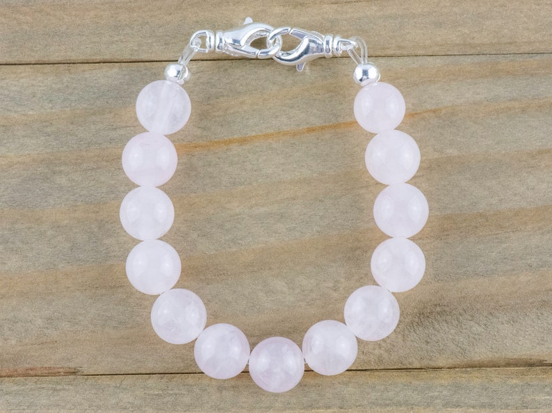 Puede incluir: Un brazalete de cuentas de cuarzo rosa con cierre de plata.