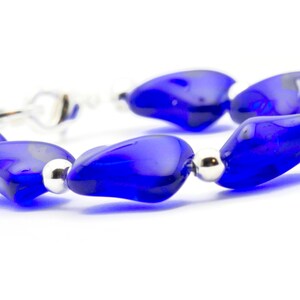 Pode incluir: Um bracelete feito de contas de vidro azul e espa&ccedil;adores de prata. As contas t&ecirc;m a forma de uma l&aacute;grima e um acabamento brilhante.