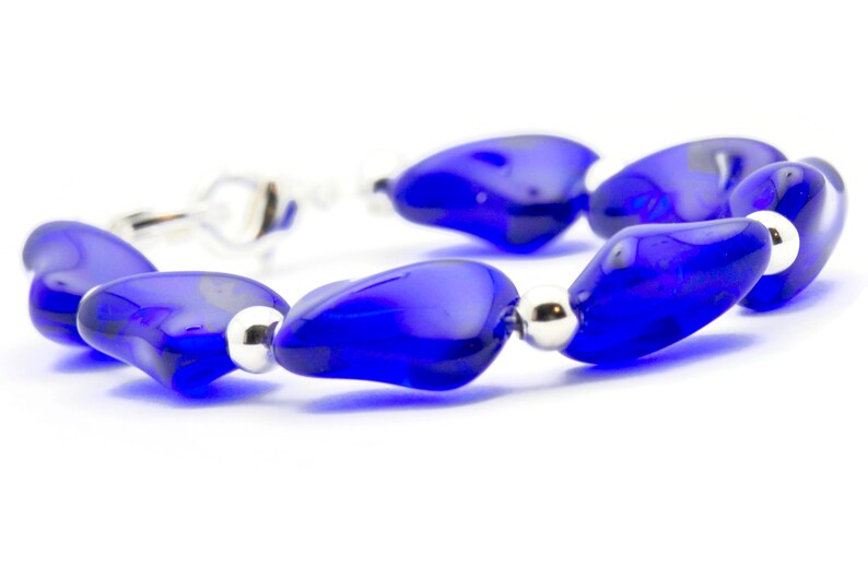Pode incluir: Um bracelete feito de contas de vidro azul e espa&ccedil;adores de prata. As contas t&ecirc;m a forma de uma l&aacute;grima e um acabamento brilhante.