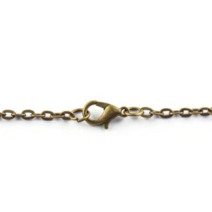 May include: A close-up of a gold-toned chain with a lobster clasp.
