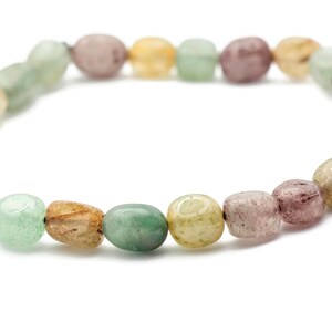 May include: A bracelet made of green, brown, and pink oval-shaped beads.