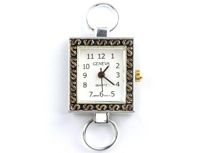 Peut inclure: Montre Geneva carr&eacute;e &agrave; quartz avec cadran blanc, chiffres noirs et aiguilles dor&eacute;es. Le bo&icirc;tier argent&eacute; est orn&eacute; d'une bordure d&eacute;corative dor&eacute;e et noire, avec un anneau argent&eacute; en haut et en bas.