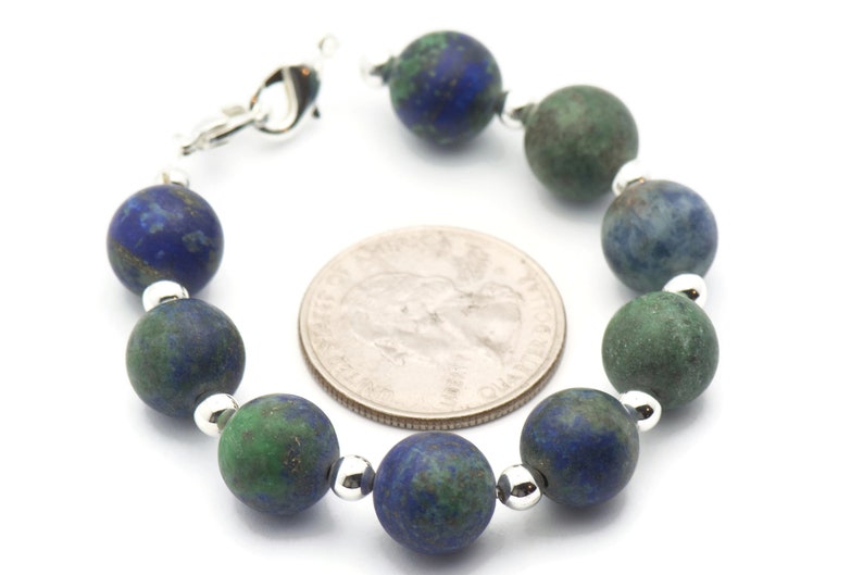 May include: A bracelet made with alternating blue and green gemstone beads. The beads are round and have a mottled appearance. The bracelet has a silver clasp.