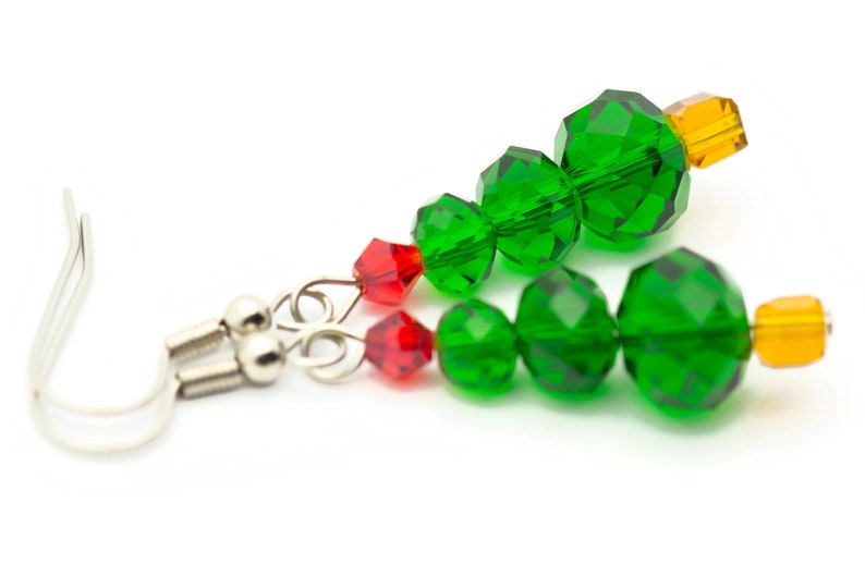 May include: A pair of green, red, and orange crystal Christmas tree earrings with silver hooks.