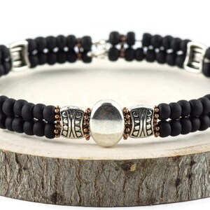 Button and Bows Jet Black Cuff Memory Wire Bracelet on a wood piece with tree bark edging