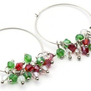 May include: Silver hoop earrings with dangling red, green, and clear crystal beads.