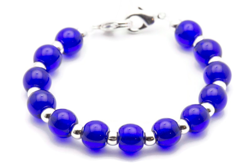 May include: A blue glass bead bracelet with silver accents. The bracelet has a clasp closure.