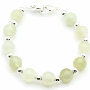 May include: A green jade stone bracelet with silver beads and a silver clasp.