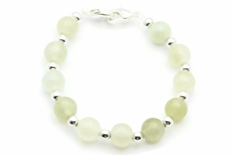 May include: A green jade stone bracelet with silver beads and a silver clasp.