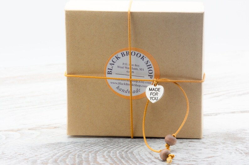 Puede incluir: Una caja de cart&oacute;n marr&oacute;n con una etiqueta que dice "Black Brook Shop" y una etiqueta en forma de coraz&oacute;n que dice "Made for You".