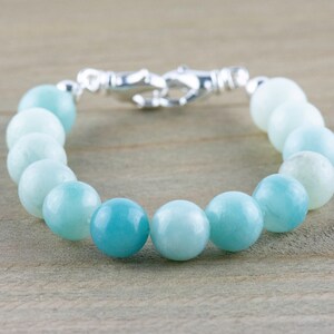 May include: A light blue aquamarine gemstone bracelet with a silver clasp.