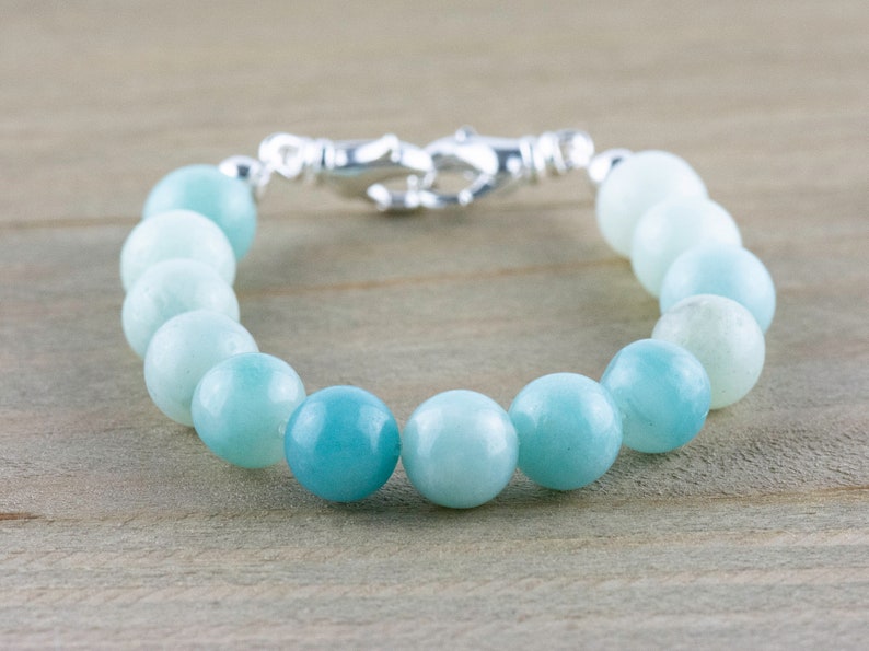 May include: A light blue aquamarine gemstone bracelet with a silver clasp.