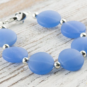 Peut inclure: Un bracelet bleu clair avec des perles rondes en verre givr&eacute; et des entretoises argent&eacute;es.