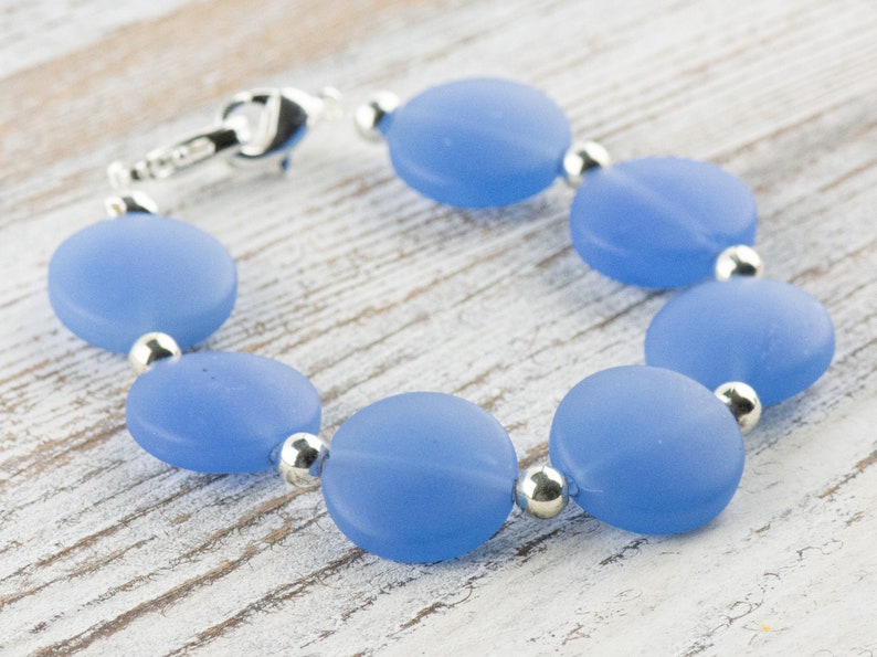 Peut inclure: Un bracelet bleu clair avec des perles rondes en verre givr&eacute; et des entretoises argent&eacute;es.