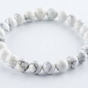 Pode incluir: Pulseira de contas de howlite branca com um design simples. As contas s&atilde;o redondas e t&ecirc;m um padr&atilde;o de m&aacute;rmore.