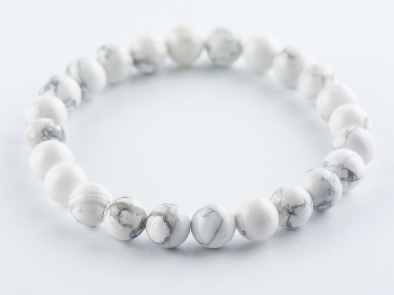 Pode incluir: Pulseira de contas de howlite branca com um design simples. As contas s&atilde;o redondas e t&ecirc;m um padr&atilde;o de m&aacute;rmore.