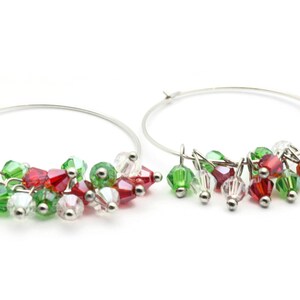 May include: Silver hoop earrings with dangling red, green, and clear crystal beads.