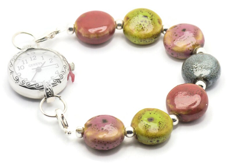 May include: A silver watch with a white face and black hands attached to a bracelet made of colourful ceramic beads. The beads are red, green, and grey.