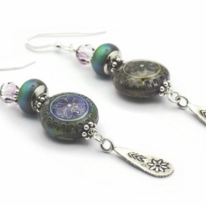 May include: A pair of silver dangle earrings with iridescent green and purple glass beads and silver flower charms.