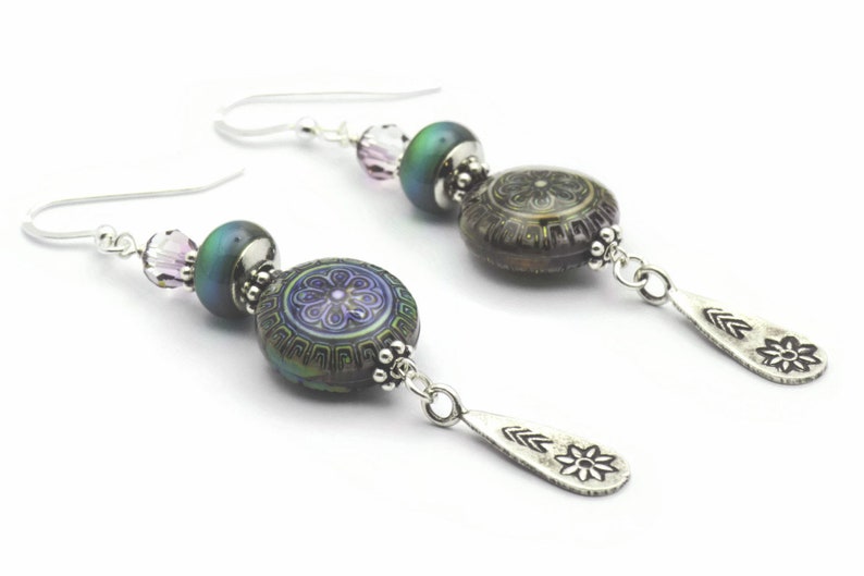May include: A pair of silver dangle earrings with iridescent green and purple glass beads and silver flower charms.