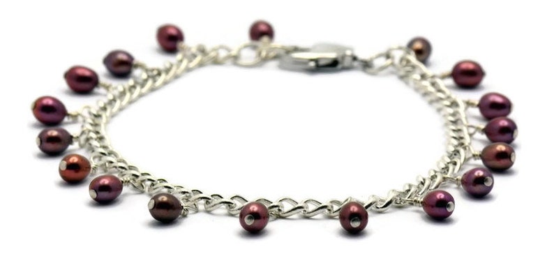 May include: A silver chain bracelet with a lobster clasp and multiple dangling maroon pearls.