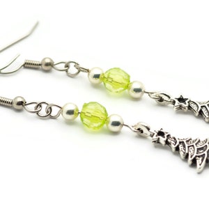 May include: A pair of silver dangle earrings with green glass beads and silver Christmas tree charms.