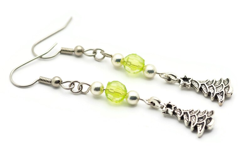 May include: A pair of silver dangle earrings with green glass beads and silver Christmas tree charms.