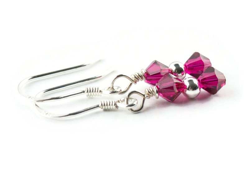 Puede incluir: Un par de pendientes de plata con cuentas de cristal rosa. Los pendientes tienen un dise&ntilde;o simple de gancho.