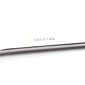 Puede incluir: Una llave inglesa plateada con la palabra "PAKISTAN" grabada en el mango.