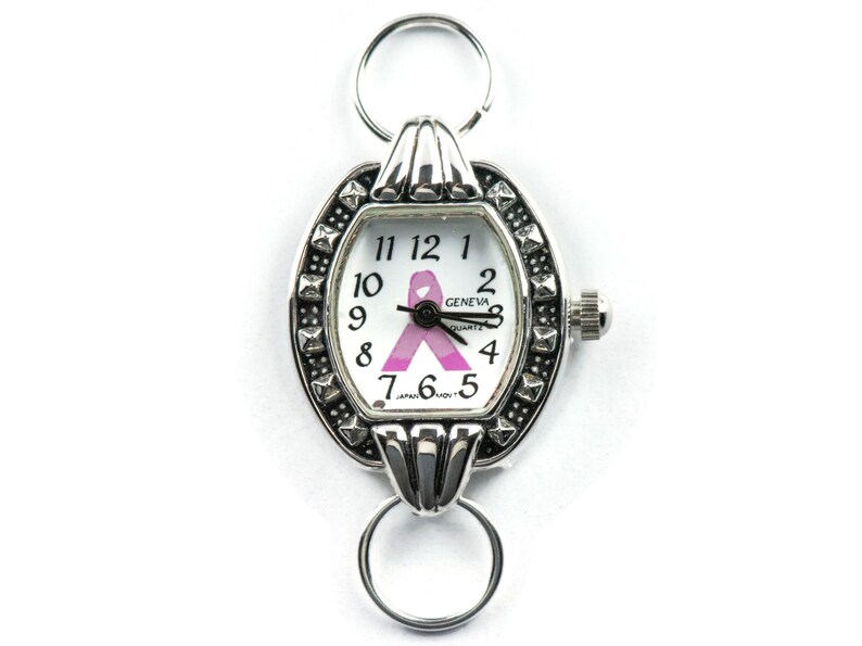 Pu&ograve; includere: Orologio color argento con un design a nastro rosa sul quadrante. L'orologio ha un movimento al quarzo Geneva ed &egrave; realizzato in Giappone.