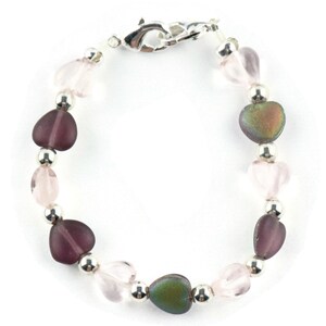 May include: A bracelet with silver beads and heart-shaped glass beads in shades of pink and purple.