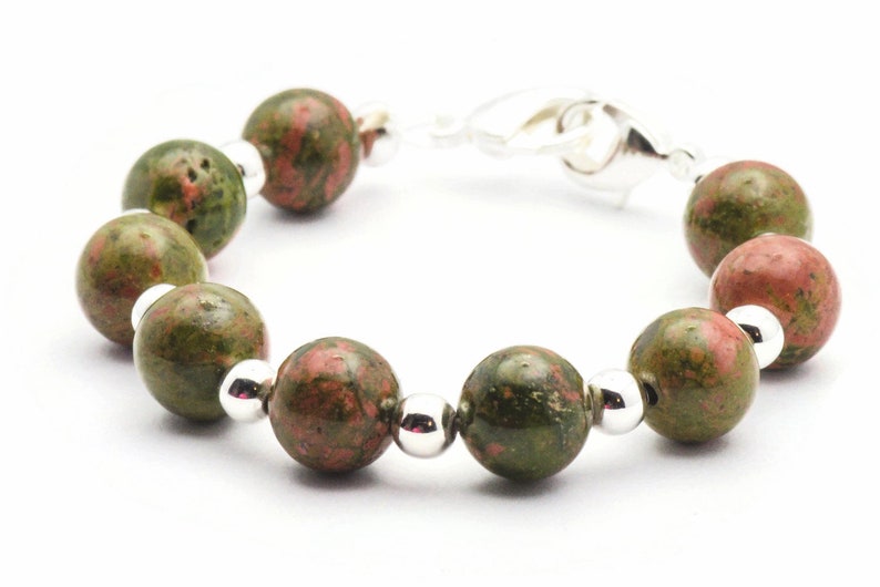 May include: A green and pink gemstone bracelet with silver beads and a silver clasp.