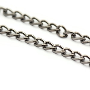 K&ouml;nnte beinhalten: Nahaufnahme einer silbernen Kette mit einem Curb-Link-Design. Die Kette ist aus Metall und hat eine gl&auml;nzende Oberfl&auml;che.