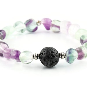 Puede incluir: Un brazalete hecho con piedras de fluorita verde, p&uacute;rpura y blanca y una cuenta de lava negra.