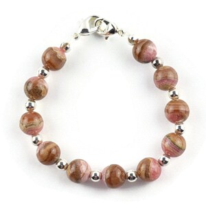 May include: A pink and brown gemstone bracelet with silver beads and a silver clasp.
