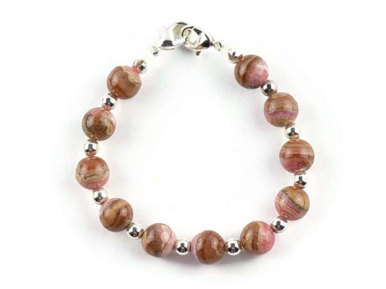 May include: A pink and brown gemstone bracelet with silver beads and a silver clasp.