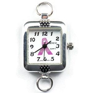 Pu&ograve; includere: Orologio quadrato color argento con quadrante bianco con numeri neri e un nastro rosa. L'orologio ha anelli nella parte superiore e inferiore per il fissaggio. Il quadrante dell'orologio recita "GENEVA QUARTZ" e "JAPAN MOV'T".