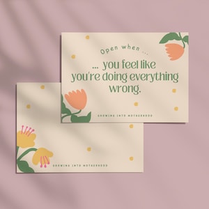 Könnte beinhalten: Zwei cremefarbene Karten mit floralen Illustrationen und dem Text "Open when... you feel like you're doing everything wrong." Die Karten haben orange und gelbe Blumen mit grünen Blättern und den Worten "GROWING INTO MOTHERHOOD."