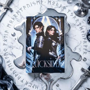 May include: A book cover featuring a male and female fantasy character with dark hair and armor. The title "QUICKSILVER" is displayed at the bottom. The background is a marble-like surface with silver decorative elements and swords.