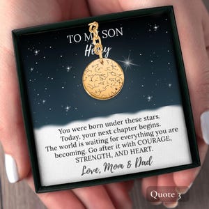 May include: A gold-colored pendant with a constellation design, presented in a black box with a starry background. The text reads "TO MY SON" and "Love, Mom & Dad". The pendant is suspended from a delicate chain.