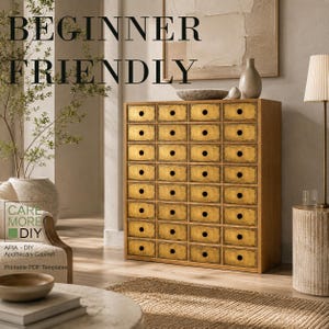 Pode incluir: Um armário de boticário de madeira com trinta e dois pequenos gavetas com frentes douradas e puxadores circulares pretos. O texto "BEGINNER FRIENDLY" e "CARE MORE DIY" é visível. O armário tem uma estrutura retangular e um layout de grade.
