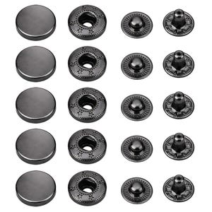 May include: A selection of dark grey metal snap fasteners. The set includes flat, round caps, decorative ring pieces with star patterns, and two-part snap components. Suitable for sewing and craft projects.