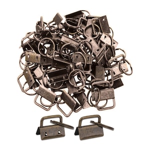 Op de afbeelding: Een verzameling antiek bronzen metalen hardware, waaronder rechthoekige sluitingen, D-ringen en sleutelringen, tegen een witte achtergrond. Twee sluitingen met pinnen worden onderaan weergegeven. Ideaal voor knutselen en het maken van sieraden.